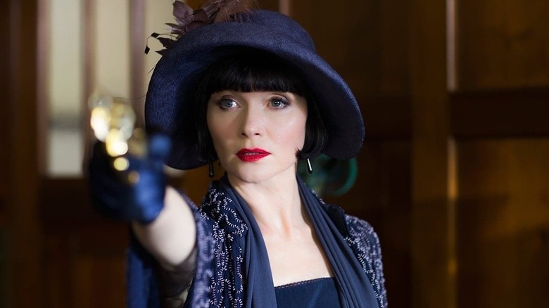 Phryne Fisher (Essie Davis) aims a pistol in Miss Fisher's Murder Mysteries