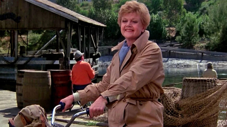 Jessica Fletcher (Angela Lansbury) smiles while sitting on a bicycle in Murder, She Wrote