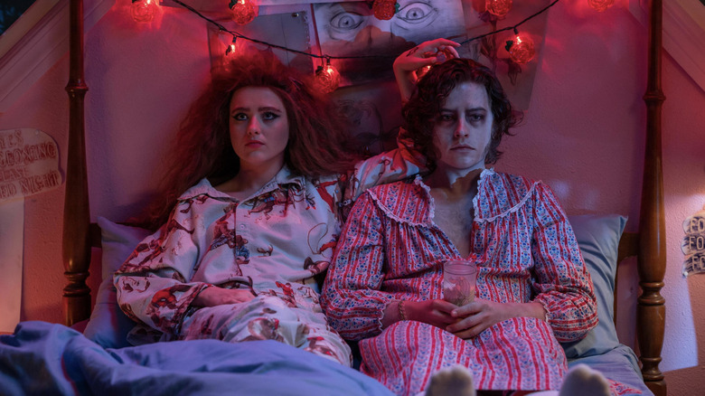 Kathryn Newton as Lisa Swallows and Cole Sprouse as The Creature sitting in bed wearing pajamas in Lisa Frankenstein