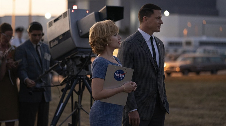 Kelly Jones and Cole Davis standing in front of a TV camera, eagerly looking at something off screen in Fly Me to the Moon