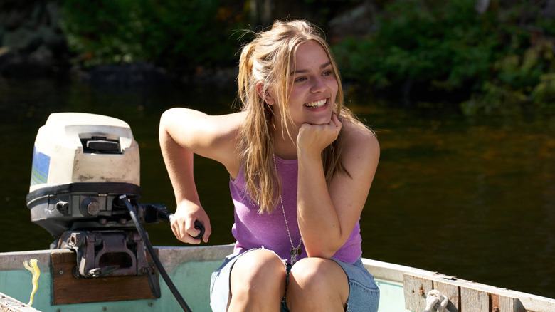 Maisy Stella as Elliott smiling on a small motorboat in a lake in My Old Ass
