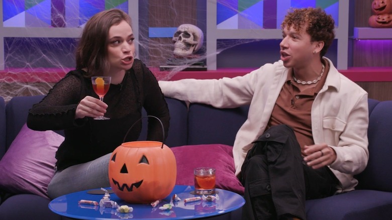 Angela Giarratana holding a drink sitting on a couch next to Chanse McCrary in Dirty Laundry