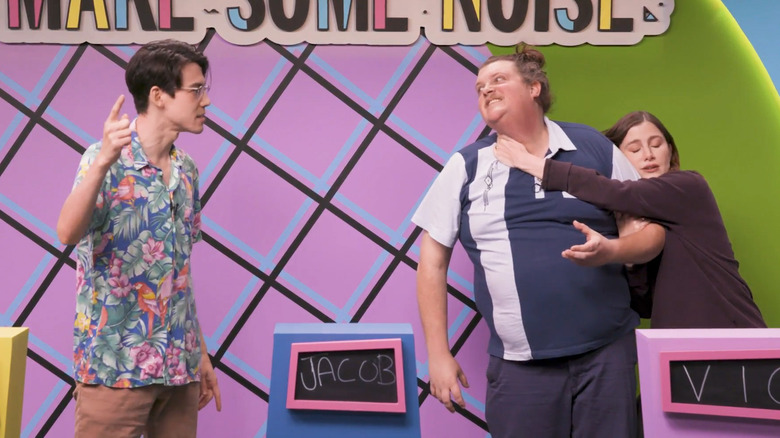 Zac Oyama, Jacob Wysocki, and Vic Michaelis acting out an improv scene behind podiums in Make Some Noise