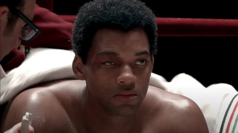 Will Smith as Muhammed Ali sitting in the corner of the boxing ring with swollen eyelid in Ali