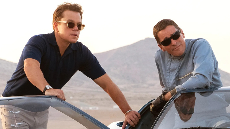 Matt Damon as Carroll Shelby stands next to Christian Bale as Ken Miles in Ford v Ferrari