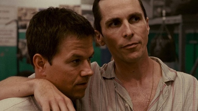 Mark Wahlberg as Micky Ward stands next to Christian Bale as his half-brother Dicky Eklund in The Fighter