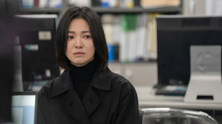 Moon Dong-eun (Song Hye-kyo) stands in an office with tears in her eyes in The Glory