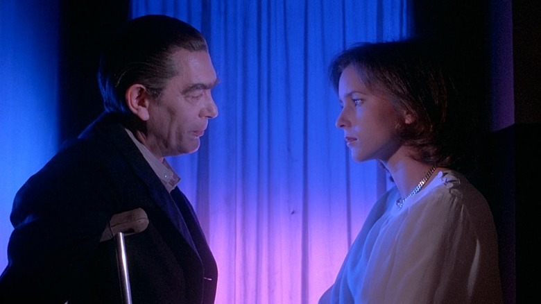 Irene Miracle as Rose Elliot and Sacha Pitoëff as Kazanian in Inferno, talking against a stark blue and pink-lit backdrop.