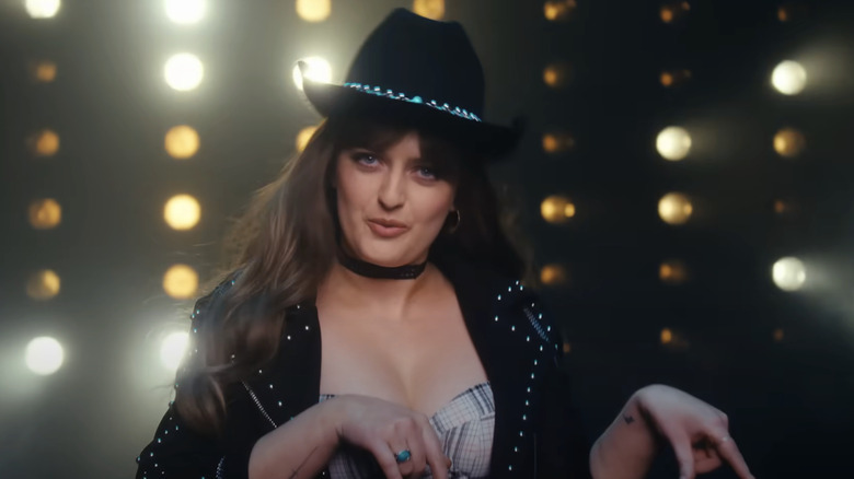 Chloe Troast singing in a cowgirl outfit in an SNL sketch