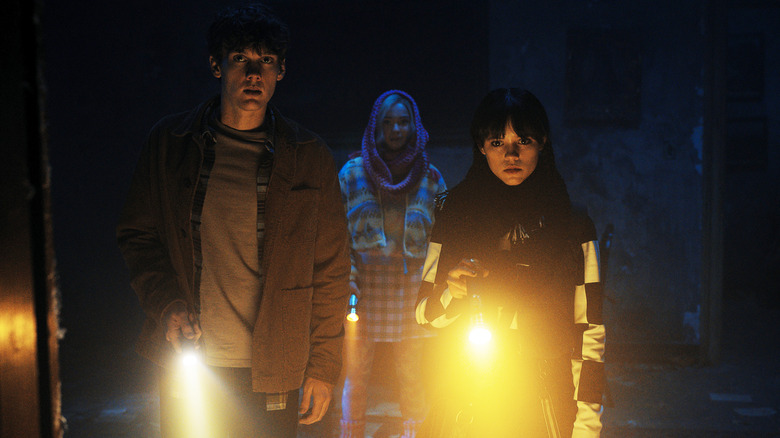 Wednesday, Tyler, and Enid with flashlights