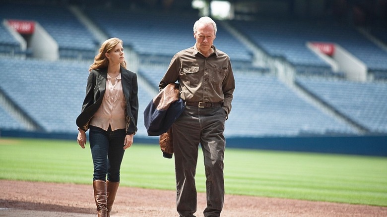 Mickey (Amy Adams) and Gus Lobel (Clint Eastwood) walk together on a baseball field in Trouble with the Curve