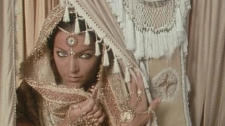 Amy Irving as Anjuli peeking through a curtain on The Far Pavilions