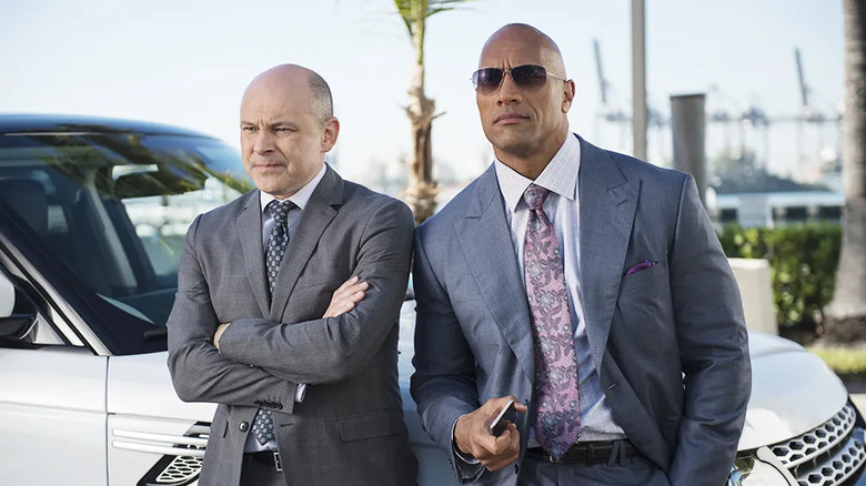 Rob Corddry and Dwayne Johnson as Joe and Spencer leaning on a car on Ballers