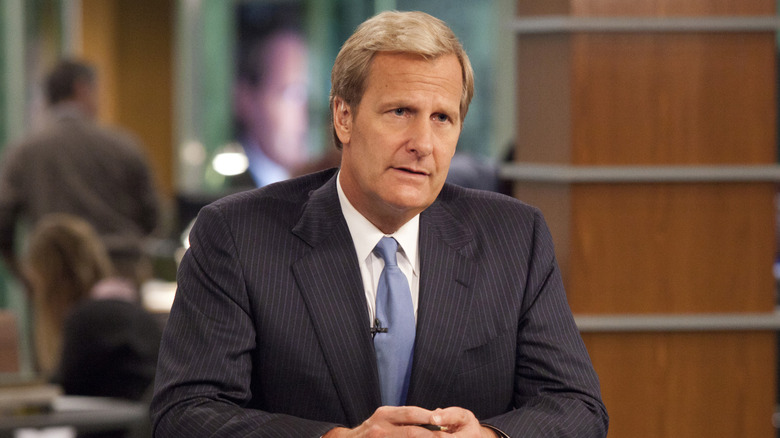 Jeff Daniels as Will McAvoy sitting behind his desk on The Newsroom