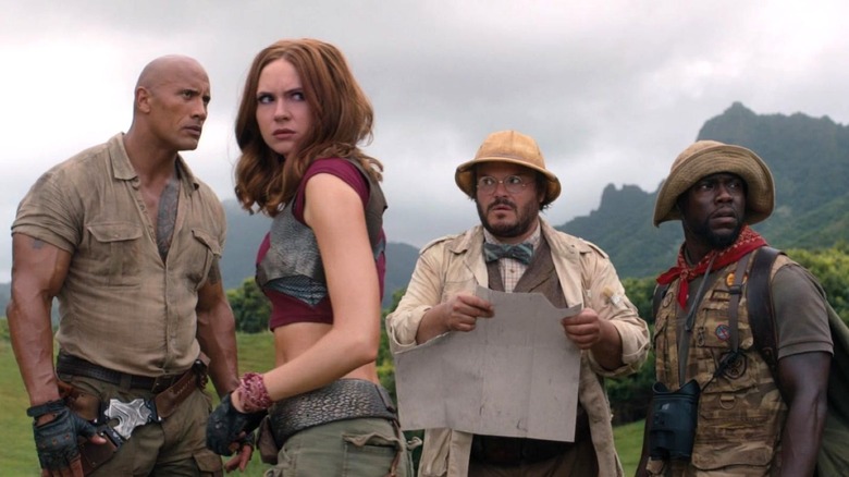 Dwayne Johnson as Spencer stands outside next to Karen GIllan as Martha, Jack Black as Bethany, and Kevin Hart as Fridge in Jumanji: Welcome to the Jungle