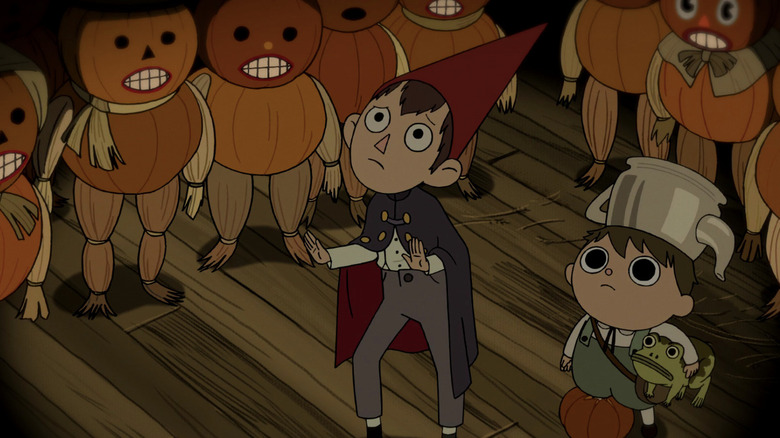 Wirt (Elijah Wood) and Greg (Collin Dean) look up while surrounded by pumpkin people in Over the Garden Wall