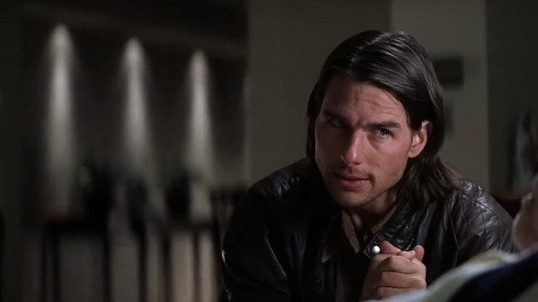 Tom Cruise with shoulder-length hair as Frank, clutching his hands with tears in his eyes in Magnolia