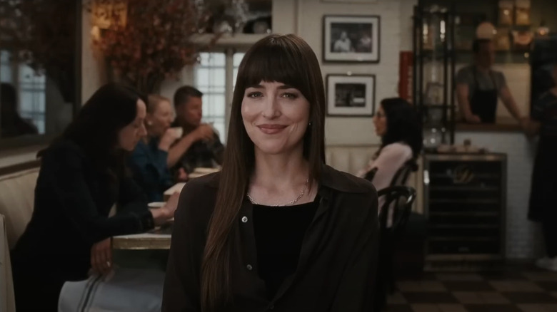 Lucy (Dakota Johnson) smirking in cafe in Materialists