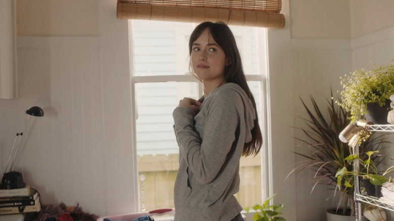 Nicole (Dakota Johnson) standing in front of window in Our Friend