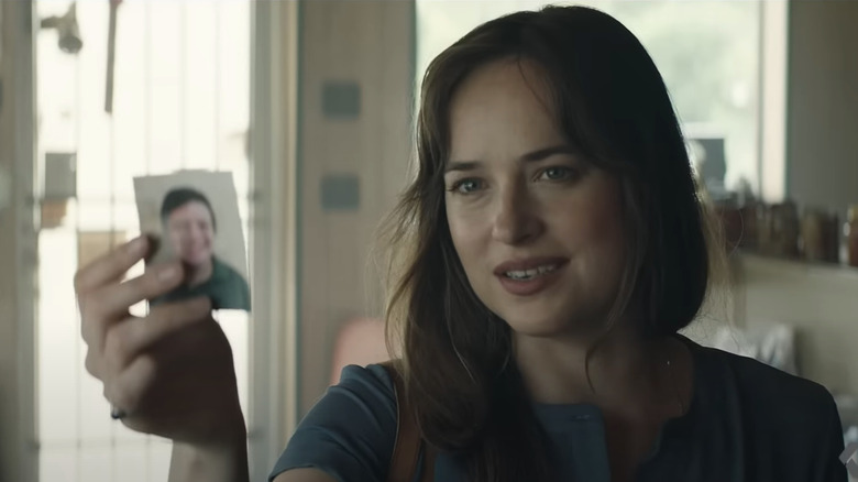 Eleanor (Dakota Johnson) holds up picture of Zak in The Peanut Butter Falcon