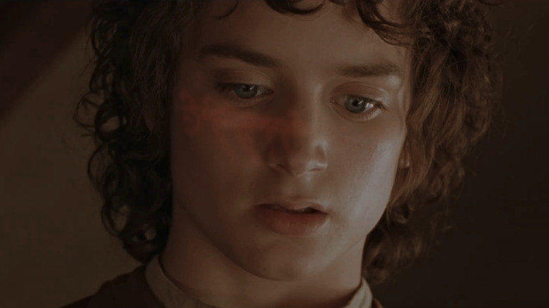 Elijah Wood as Frodo with the text of the One Ring glowing on his face in The Fellowship of the Ring
