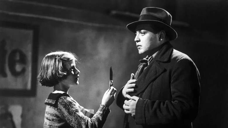 A little girl hands Hans a knife