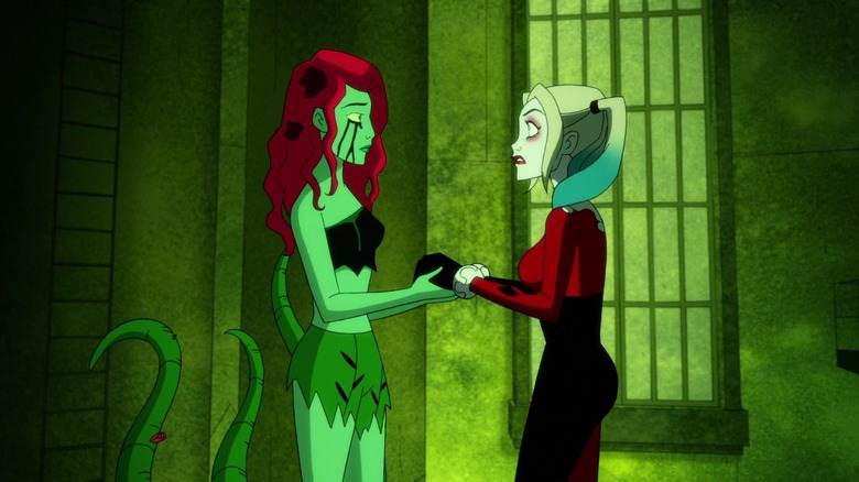 Harley Quinn's Ivy in ripped green outfit holding Harley's hands