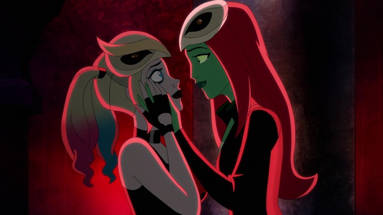 Harley Quinn's Ivy holding Harley's face in her hands bathed in red light
