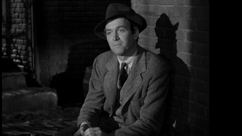 James Stewart looks whimsical, sitting in alley