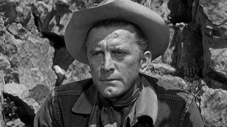 Jack Burns (Kirk Douglas) looks stern in front of a rock formation in Lonely Are The Brave