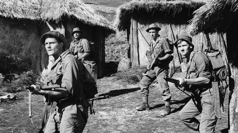 Four British soldiers ready their rifles in a Korean village in A Hill in Korea