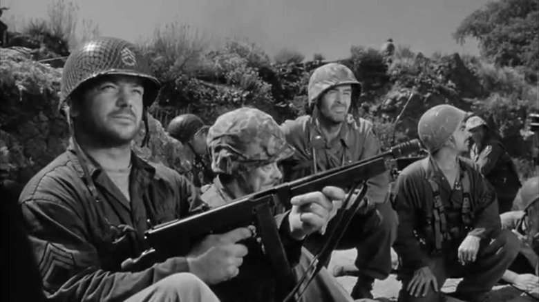 Sergeant Montana (Aldo Ray) and Lieutenant Benson (Robert Ryan) crouch with their troops in Men in War