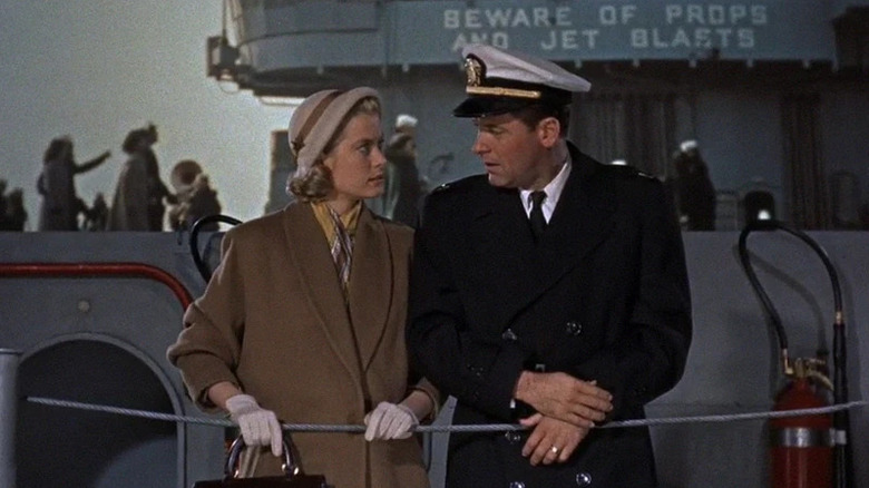 Nancy Brubaker (Grace Kelly) stands next to Harry Brubaker (William Holden) by a ship's railing in The Bridges at Toko-Ri