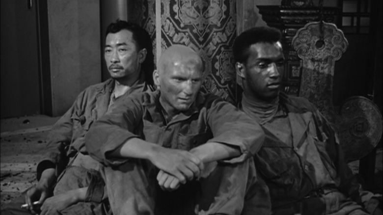 Tanaka (Richard Loo), Baldy (Richard Monahan), and Thompson (James Edwards) rest by a pillar in The Steel Helmet