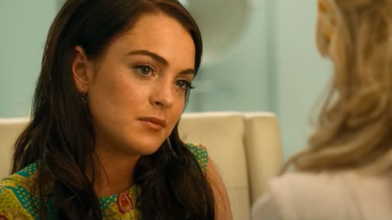Lindsay Lohan with dark hair sitting across from blonde woman