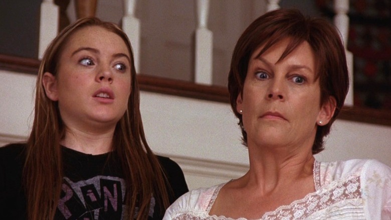 Jamie Lee Curtis with hands on her face standing next to Lindsay Lohan in Freaky Friday