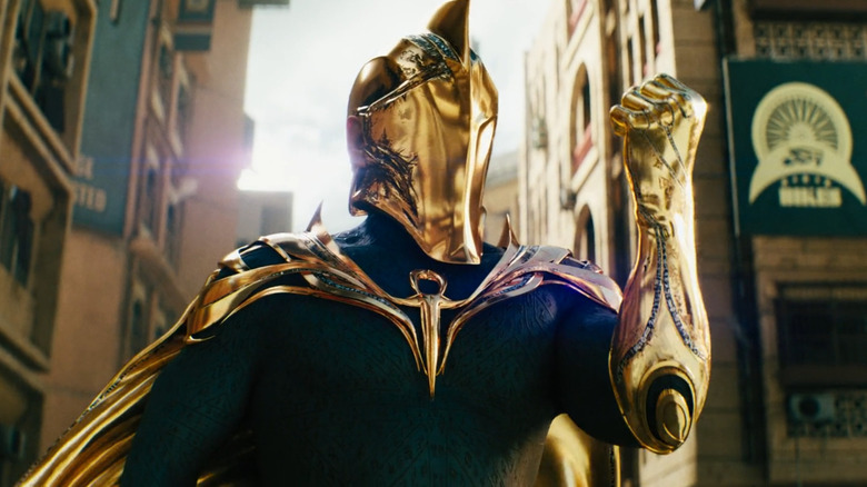 Pierce Brosnan as Doctor Fate in his blue and gold armor in a city in Black Adam