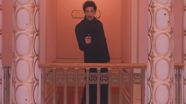 Dmitri Desgoffe-und-Taxis (Adrien Brody) holding a gun in The Grand Budapest Hotel