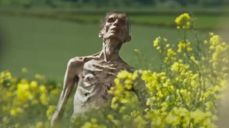 An emaciated man-thing rises from the ground in 28 Years Later