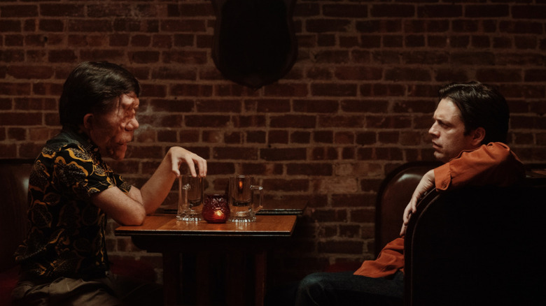 Oswald and Edward sitting at a table in a bar in A Different Man (2024)
