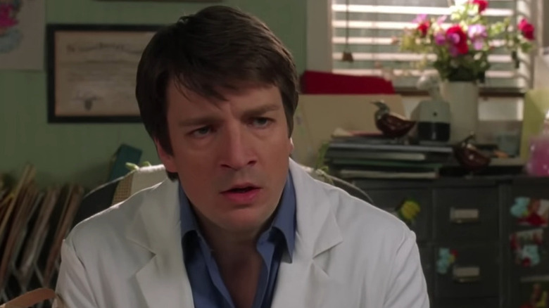 Dr. Jim Pomatter (Nathan Fillion) at his desk in Waitress