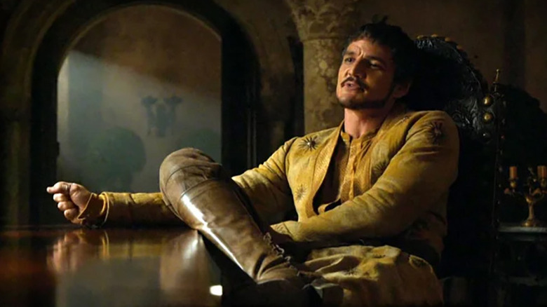 Oberyn Martell (Pedro Pascal) sits arrogantly at a table in Game of Thrones