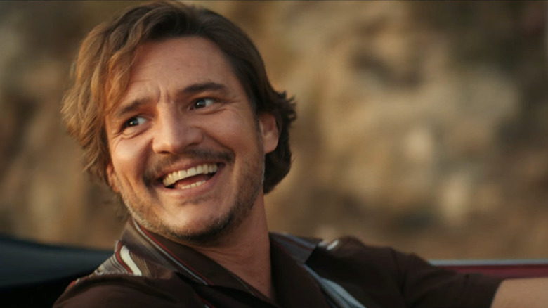 Javi Gutiérrez (Pedro Pascal) smile widely while driving a convertible in The Unbearable Weight of Massive Talent