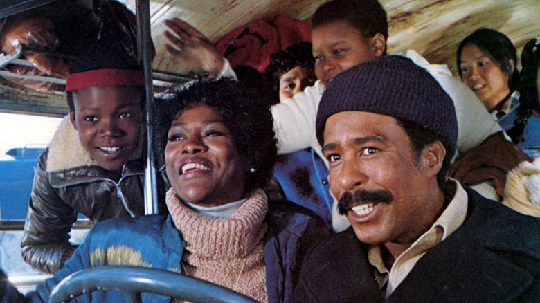 Joe Braxton (Richard Pryor) drives a bus alongside Vivian Perry (Cicely Tyson) with children behind them in Bustin' Loose