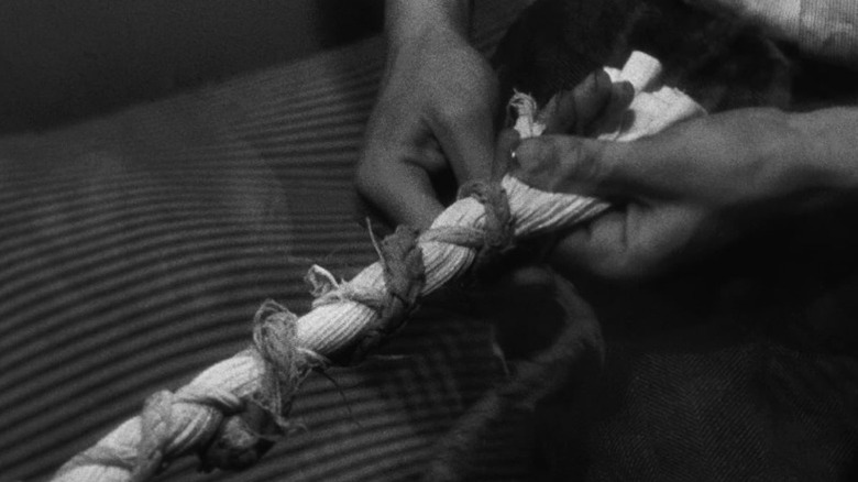 Hands weaving ropes together in A Man Escaped