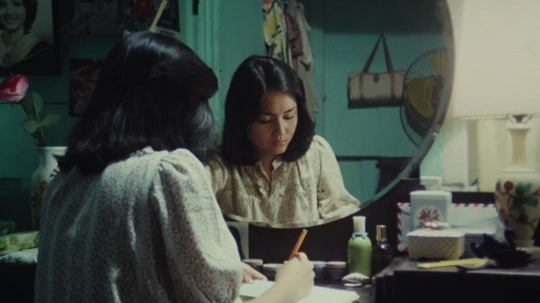 Charo Santos as Mila Carandang sitting at a dressing table and writing in Kisapmata