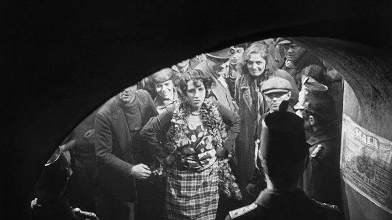 Crowd of people standing in front of police officers at the entrance of a tunnel in M
