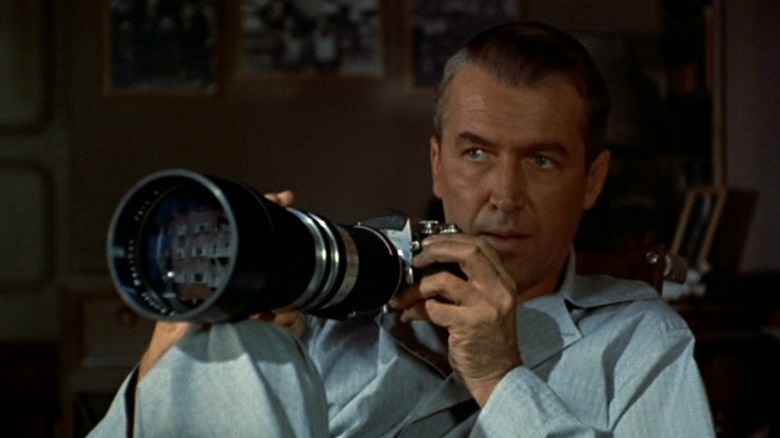 James Stewart as L.B. "Jeff" Jefferies sitting in his wheelchair and holding a camera in Rear Window
