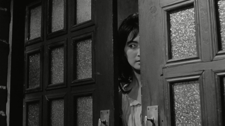 Lee Eun-shim as Myung-sook peering through a half-open door in The Housemaid