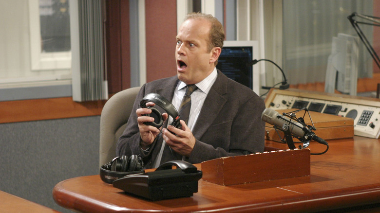 Frasier Crane (Kelsey Grammer) looks shocked at his radio desk in Frasier